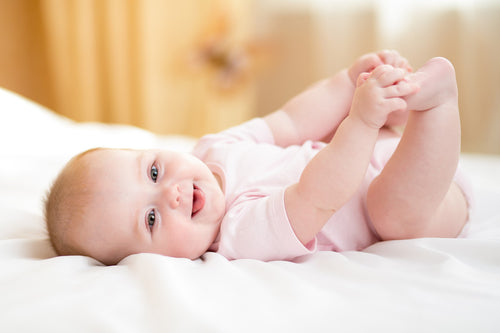 Infant wearing Pink Bambini mittens